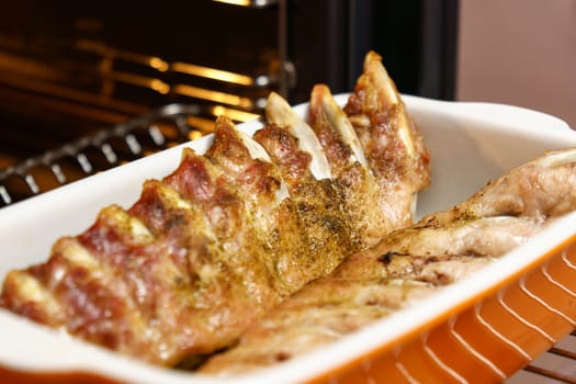 Man taking baking tray, Oven grilled spareribs on a baking. Selective focus