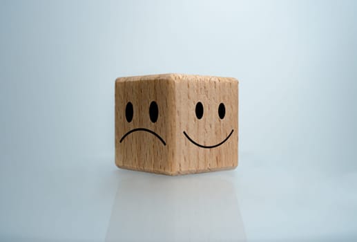 Mental health and emotional state concept, Smile face  and sad face on wooden block cube for positive mindset selection concept.