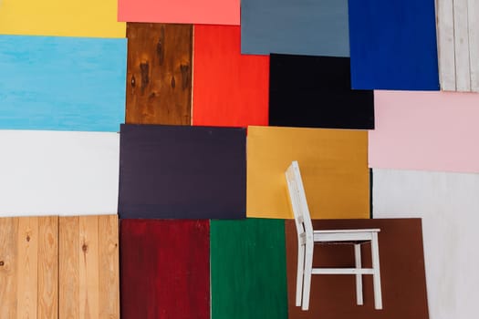a backgrounds of different colors with white chair red blue brown black