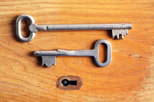 Set of various old keys closeup near keyhole