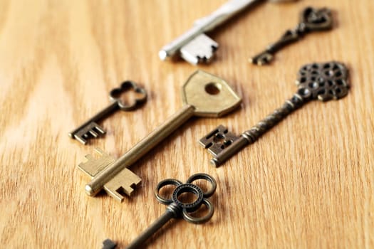 Set of various keys on wooden surface