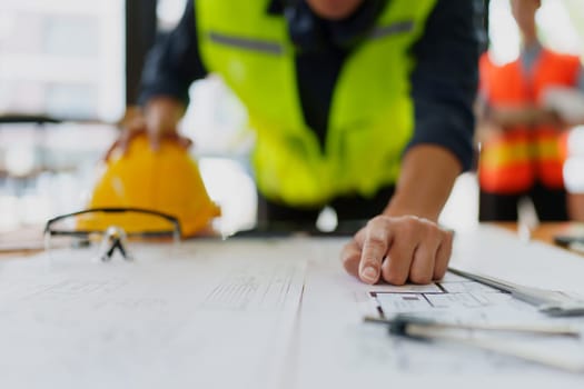 engineers discuss building on blueprint drawing, design building Project in office