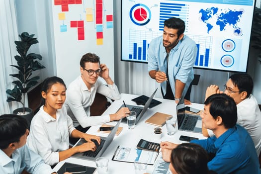 Analyst team utilizing BI Fintech to analyze financial data at table in meeting room. Businesspeople analyzing BI dashboard power for business insight and strategic marketing planning. Prudent