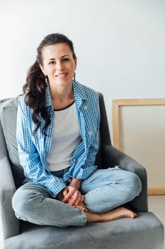 woman in blue jeans sitting on a chair