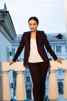 business woman in a business suit stands on the balcony