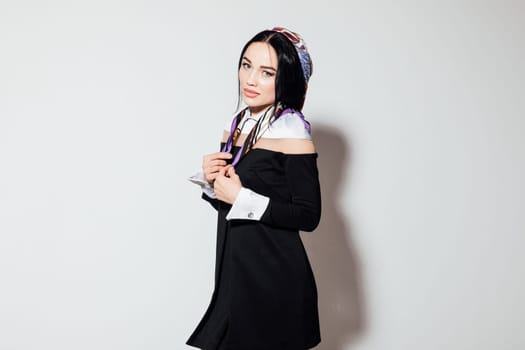 fashionable woman in a scarf on her head in a black dress pensive