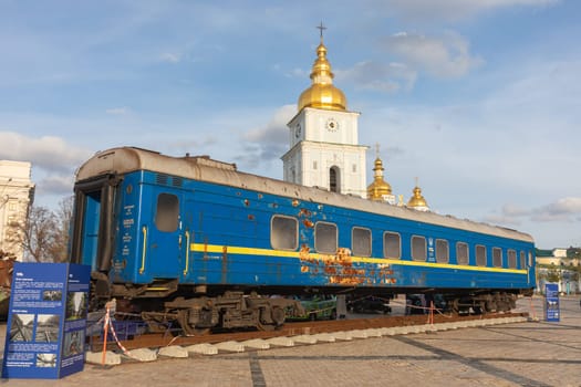 KYIV, UKRAINE - Nov. 10, 2023: A Ukrainian railway carriage shot by Russian troops is seen in front of the Mykhailivska Church on Mykhailivska Square in Kyiv. 