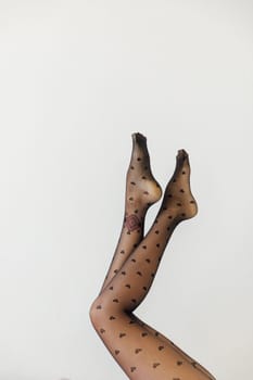 a women's slender legs in black tights on a white background