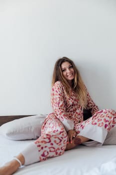 woman in sleep clothes sits in bed in the bedroom
