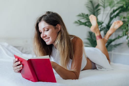 woman in bed reading a book in the bedroom in the morning