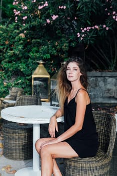 woman sitting in an outdoor restaurant in the summer walk waiting for food