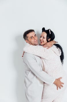 a husband and wife man and woman in love in pajamas in the morning in a bright room