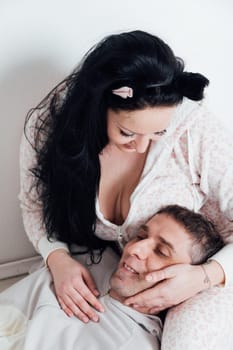 a husband and wife man and woman lovers in the morning in the bedroom woke up