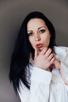 a woman brunette adjusts lipstick lipstick on lips with her hand