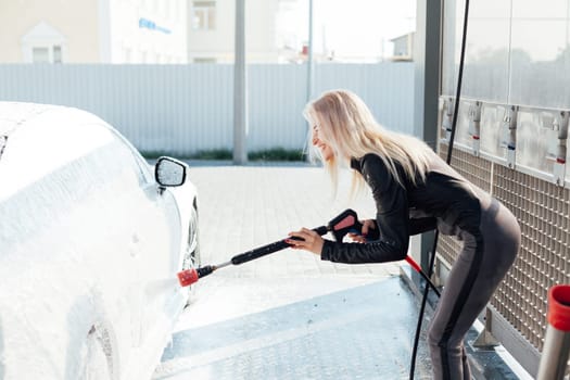 woman in a car washes a car with foam