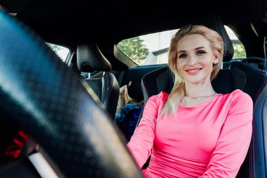 elegant blonde woman in pink dress rides behind the wheel driver