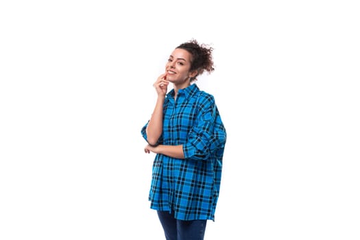 young pretty slender woman with careless curly hairstyle dressed in oversized casual shirt.