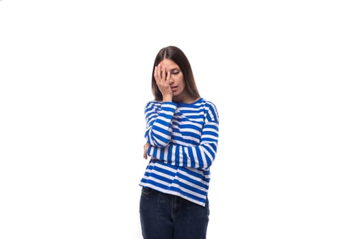 portrait of a young pretty caucasian woman with dark hair dressed in a blue striped sweatshirt on a white background. people lifestyle concept.