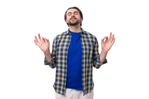 portrait of a pleasant calm young european brunette with a beard dressed stylishly in a shirt.