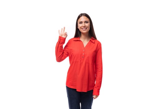 portrait of a young caucasian brunette office worker woman dressed in a red blouse on a white background.