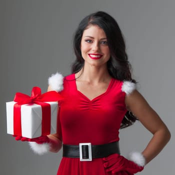 Woman in red Santa Claus outfit holding christmas gift box