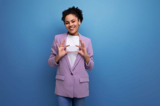 young latin business woman with ponytail hairstyle dressed in purple jacket on studio background with copy space.