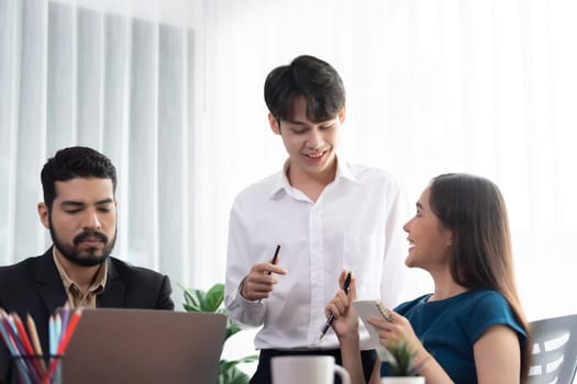 Professional Asian employee work together as team in corporate office, discussing business plans and data to achieve success on desk with laptop. Modern office worker teamwork concept. Concord
