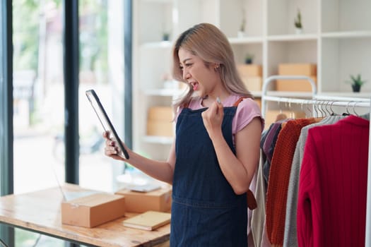 Portrait Of Asian Female Owner Of Fashion Store Clothing Store successful happy smile at small business, sme or ecommerce concepts.