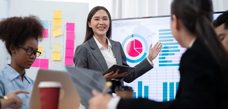 Young asian businesswoman presenting data analysis dashboard on TV screen in modern meeting. Business presentation with group of business people in conference room. Concord