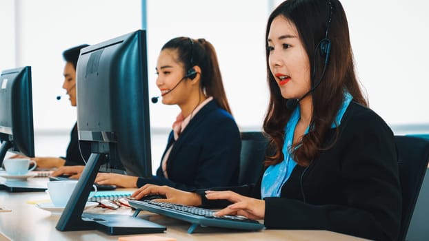 Business people wearing headset working in office to support remote customer or colleague. Call center, telemarketing, customer support agent provide service on telephone video conference call. Jivy