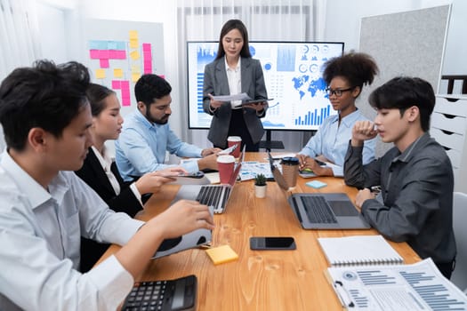 Young asian businesswoman presenting data analysis dashboard on TV screen in modern meeting. Business presentation with group of business people in conference room. Concord