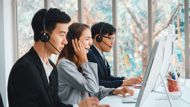 Business people wearing headset working in office to support remote customer or colleague. Call center, telemarketing, customer support agent provide service on telephone video conference call. Jivy