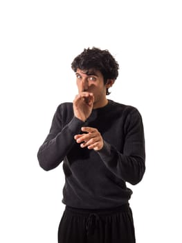 Young man doing hush sign with finger over his mouth, looking at camera, isolated on white, silencing