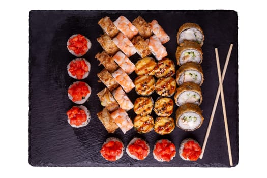 Sushi set on slate plate isolated on white background. 5 types of rolls in one set. Top view.