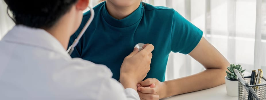 Patient attend doctor's appointment at clinic or hospital office. Doctor examining and diagnosis symptoms while checking the patient's pulse with stethoscope. Panorama Rigid