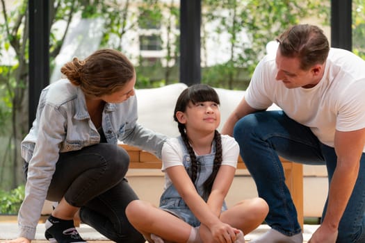 Parents comforting their daughter with loving embrace, helping her feel secure and protected as she rest her head on their shoulder. Happy family love and child care support concept. Synchronos