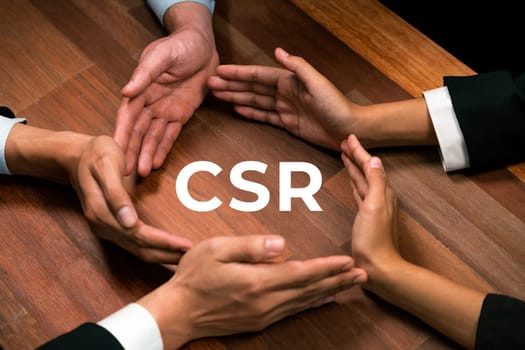 Top view group of business people forming circle hand together around eco-friendly CSR icon on meeting table as concept of corporate responsible for sutainable society and greener community. Quaint