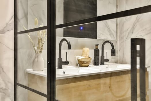 a bathroom with white marble walls and black trim around the sink, while it's reflected in the mirror