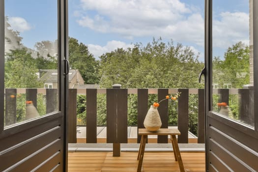 an outside area with wood flooring and wooden doors leading to the patio, looking out onto trees in the distance