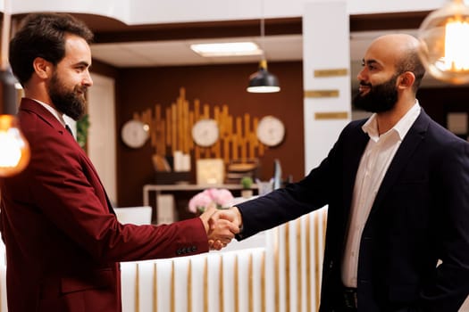 Business partners agreeing on collab, travelling for work to attend important corporate meeting. Two executive managers shaking hands in agreement to start fruitful partnership.