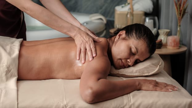 Asian woman getting a Thai massage in a Massage room in Thailand at a luxury hotel spa, close up of woman hands giving a massage