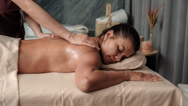 Asian woman getting a Thai massage in a Massage room in Thailand at a luxury hotel spa, close up of woman hands giving a massage