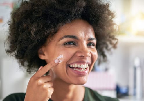 Face, woman and laugh with lotion for skincare for pigmentation, texture or dermatology in home. Black person, happy and application of spf, sunscreen or moisturiser for sun, protection or treatment.