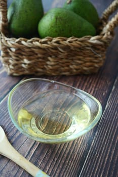 oil and slice of avocado on wooden table .