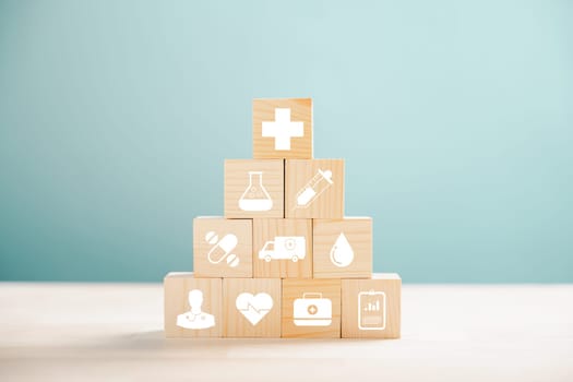 Metaphorical representation of healthcare and insurance with pyramid of wooden cubes. Medical insurance icon on white background, allowing copyspace for Health Insurance concept.