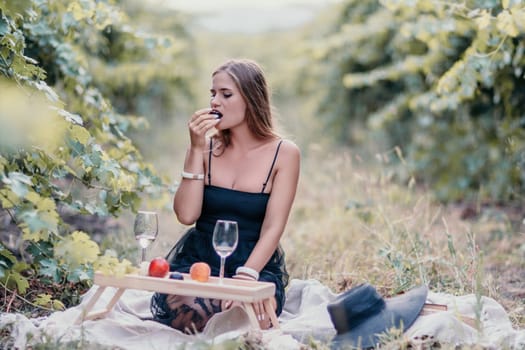 Picnic and wine tasting at sunset in the hills of Italy, Tuscany. Vineyards and open nature in the summer. Romantic dinner, fruit and wine.