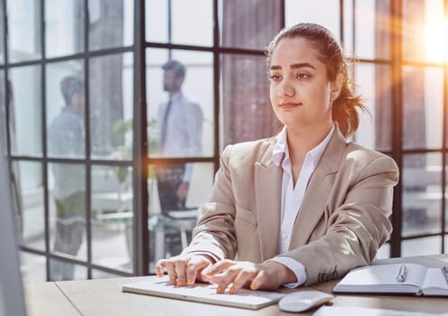 A girl works at a computer in a modern office