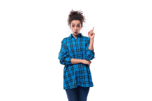 young smart curly brunette woman in a blue plaid shirt on a white background.