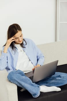 Woman sitting on couch with noitbook online