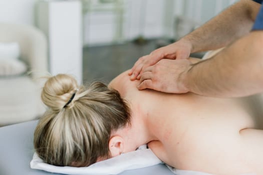 Plump woman getting hot stones arm massage in a spa salon. Therapy, wellness and relaxation concept